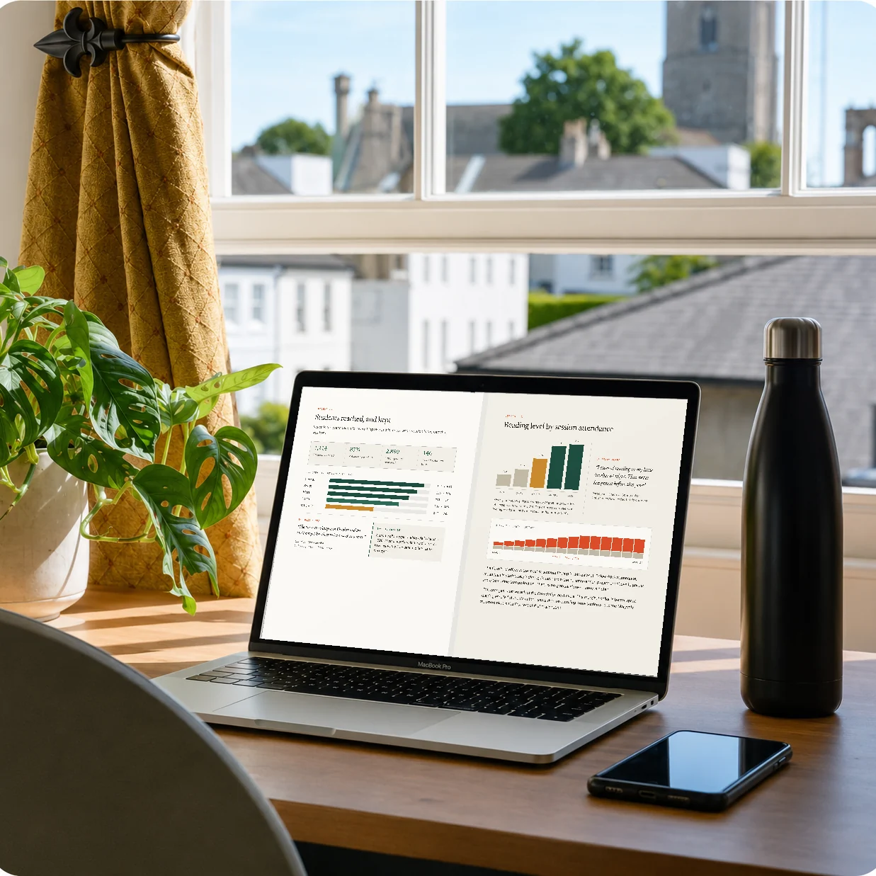 A laptop on a desk by a window, showing two pages of the illustrative Instrumento sample report